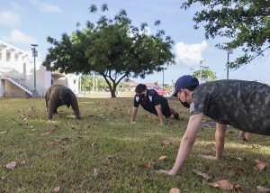 (From left) Triton Esports athletes Bill Lactaoen, Ronee Pangilinan, and Daniel Lee do pushups as part of the daily physical fitness component of their team training.